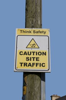 caution site traffic sign on a wooden telegraph pole