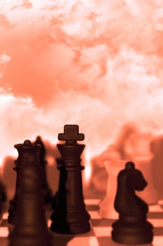 chess pieces isolated against a cloudy red sky background