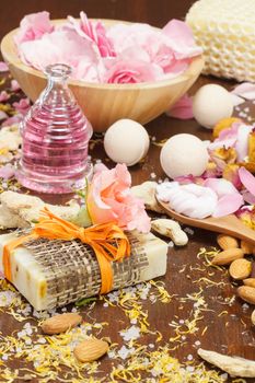 Fizzy bath bomb with natural handmade soap, rose petals and almonds, homemade spa concept. Selective focus