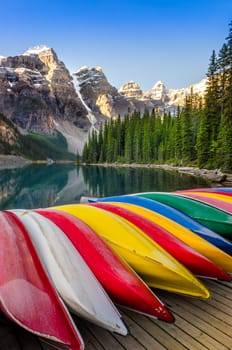 Landscape view of Moraine lake with colorful boats foreground, Canadian Rocky Mountains