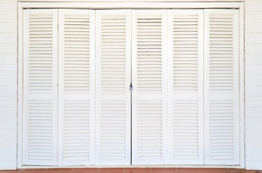 White wooden doors are closed and locked with a key.
