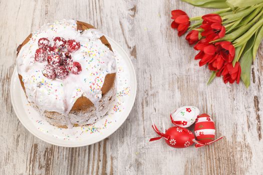 Easter cake, eggs and bunch of tulips. High angle view. Copy space