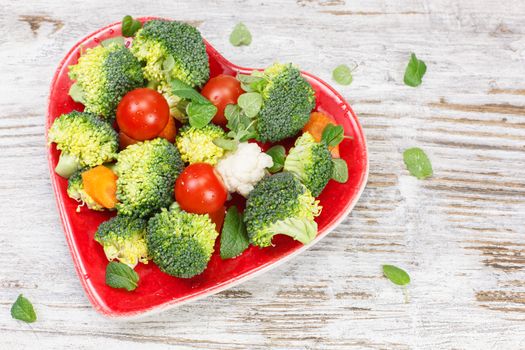 Raw vegetable in heart shaped plate. Diet concept. Macrobiotic.