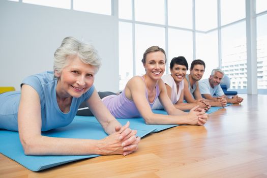 Portrait of a fitness group lying in row at the yoga class