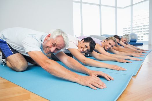 Portrait of fitness group bowing in row at the yoga class