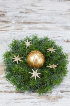 Christmas wreath with bauble on the old wooden background. Copy space composition
