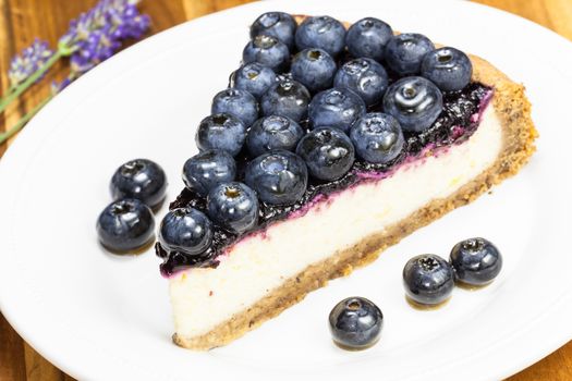 Blueberry pie. Slice of cake with blueberries close up on a white plate