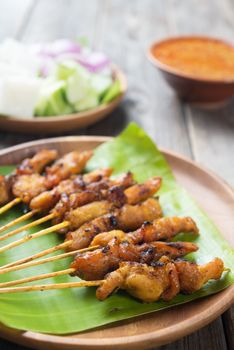 Close up chicken satay on wooden dining table, one of famous local dishes.