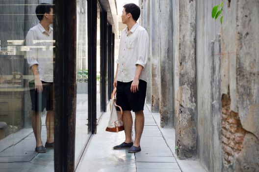 Attractive man with canvas bag at abandoned alleyway