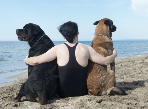 young woman on the beach with her dogs