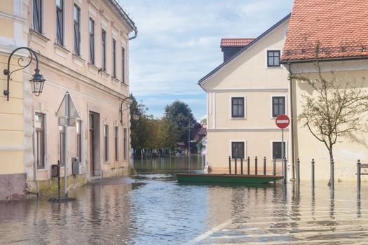 Rural village houses in floodwater. Road with the river overflown with the residents in their homes. Floods and flooding the streets. Natural disaster.  