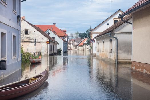 Rural village houses in floodwater. Road with the river overflown with the residents in their homes. Floods and flooding the streets. Natural disaster.  