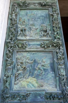 PISA, ITALY - AUGUST 11, 2013: Battistero Pisa entrance bronze gate detail, Piazza del Duomo, Italy