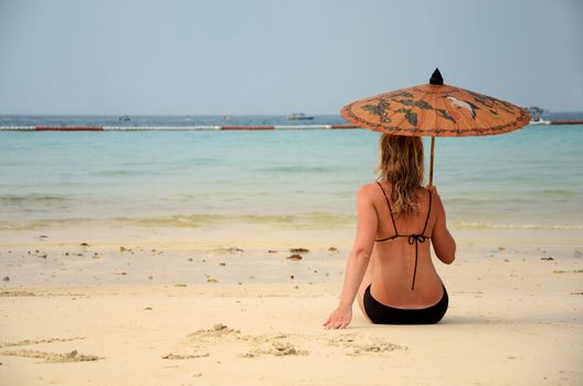 woman resting on the beach under sky