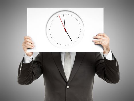 A business man holding a paper in front of his face with a clock