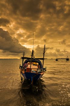 Fishing sea boat and Sunrise clouds before strom in Thailand gold light tone