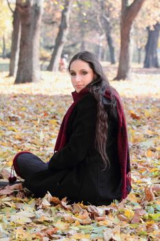 Beautiful young woman sit on the leaves