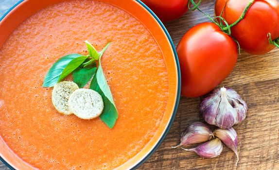 Bowl of tomato soup gaspacho with basil and crackers