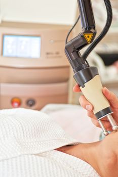 Woman getting laser face treatment in medical center, skin rejuvenation