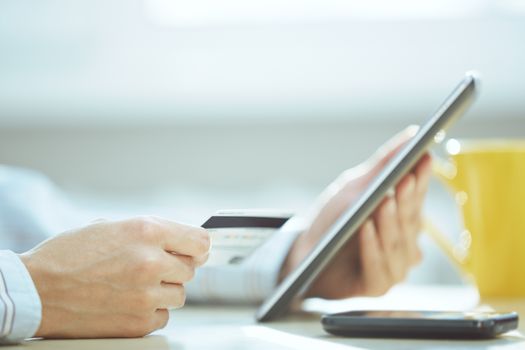 Human hands with tablet PC and credit card during lunch