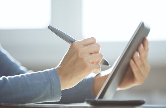 Hands of designer working with tablet PC and stylus