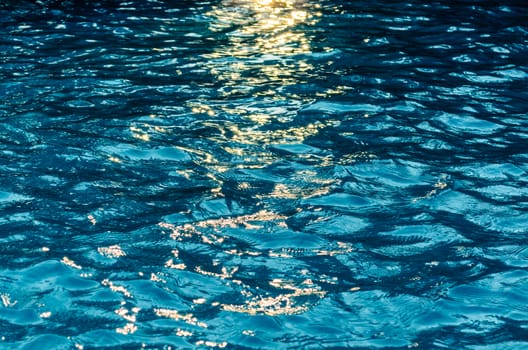 Beautiful surface of blue water reflects sunlight in the evening.
