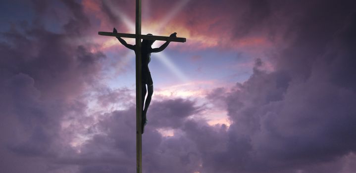 Jesus Christ on the Cross with sunset clouds as a background