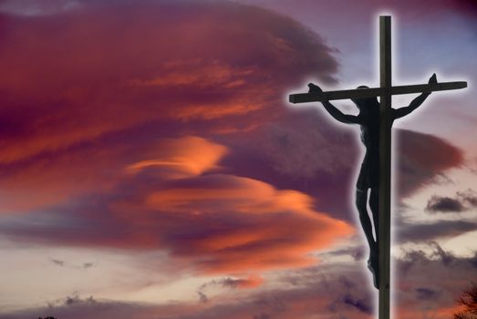 Jesus Christ on the Cross with sunset clouds as a background