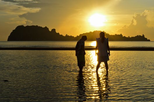 Two people sisters and brothers are enjoying strolling in the sea near Hat Sai Ri beach, Chumphon Province of Thailand