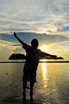 Woman with a cheerful demeanor to see sunrise at Hat Sai Ri beach in Chumphon Province of Thailand