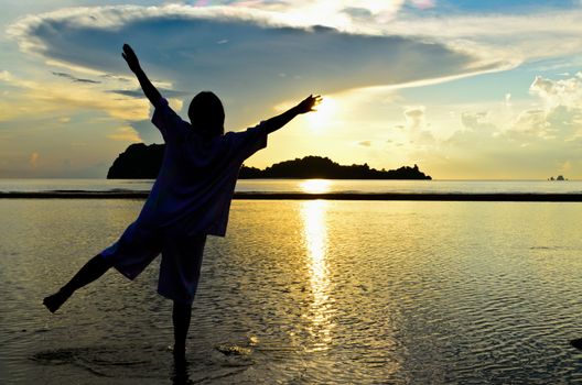 Woman with a cheerful demeanor to see sunrise at Hat Sai Ri beach in Chumphon Province of Thailand