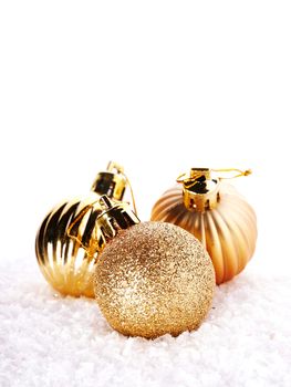 New Year's brilliant balls on snow. New Year's golden balls. Christmas balls. Christmas tree decorations. Christmas jewelry.