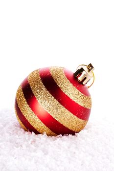 New Year's striped ball on snow. New Year's red ball. Christmas ball. Christmas tree decorations. Christmas jewelry.