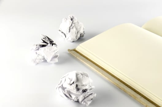 crumpled paper and notebook on a white background