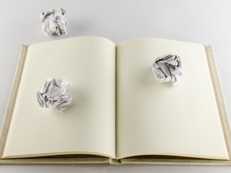crumpled paper and notebook on a white background