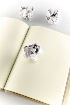 crumpled paper and notebook on a white background