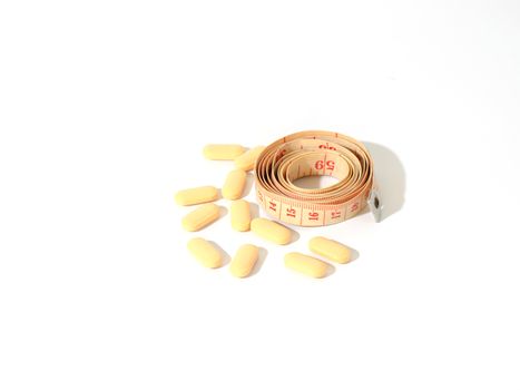 pills and measuring tape on a white background