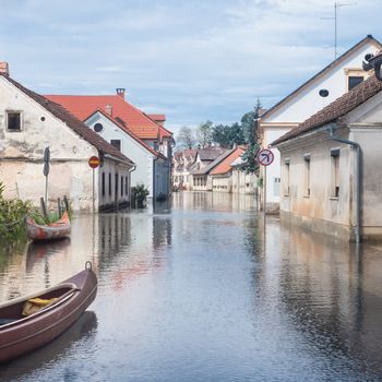 Rural village houses in floodwater. Road with the river overflown with the residents in their homes. River Krka floods and flooding the streets. Natural disaster in Kostanjevica, Slovenia.  