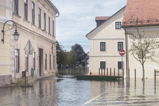 Rural village houses in floodwater. Road with the river overflown with the residents in their homes. River Krka floods and flooding the streets. Natural disaster in Kostanjevica, Slovenia.  