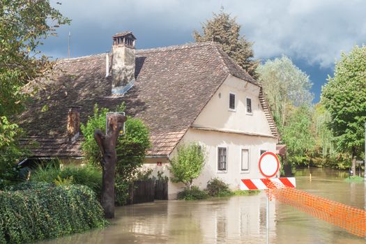 Rural village houses in floodwater. Road with the river overflown with the residents in their homes. River Krka floods and flooding the streets. Natural disaster in Kostanjevica, Slovenia.  