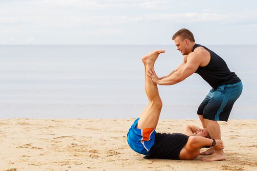 Sport, fitness. Bodybuilders during workout on the beach