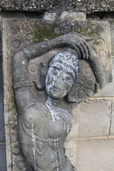 The old sculpture lean against the wall.It is the high relief sculpture.But it fractured and not in use.