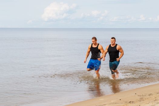 Two guys running on the beach