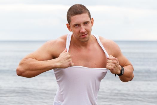 Sport, fitness. Bodybuilder in torn shirt