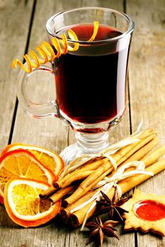 Glass of red mulled wine on wooden table