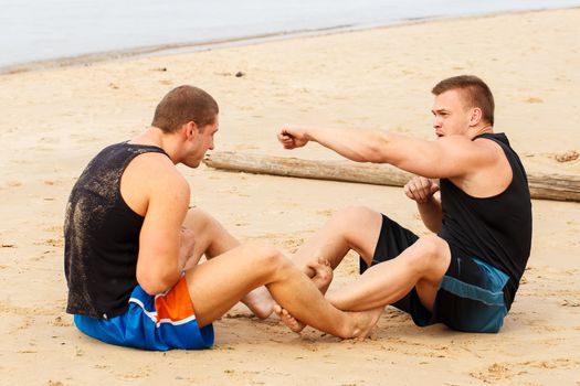 Sport, fitness. Bodybuilders during workout on the beach