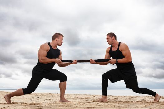 Sport, fitness. Bodybuilders during workout on the beach