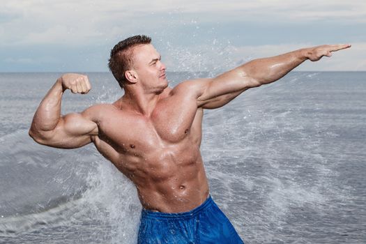 Sport, fitness. Bodybuilder with sexy body on the beach