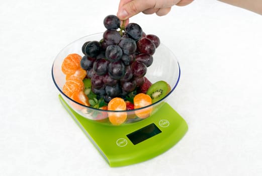 Lots of fruit on the kitchen scale in a modern kitchen