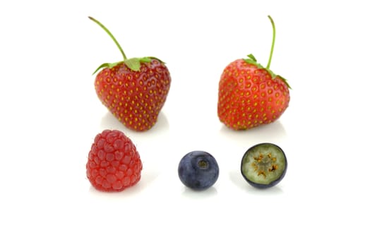 Strawberries, blueberries and a raspberry isolated on white